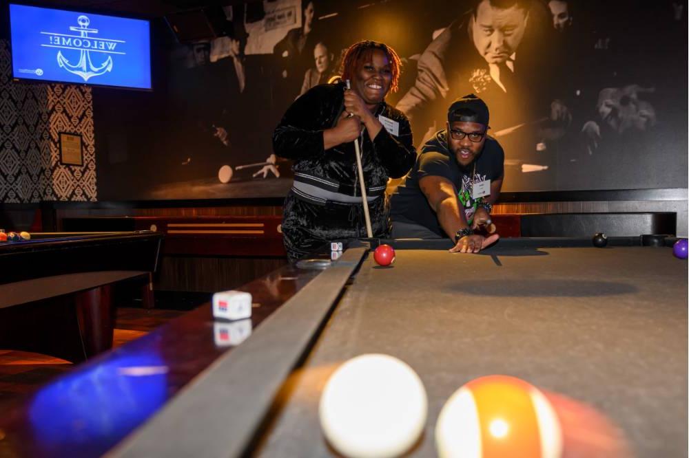 Two alumni playing pool at the event.